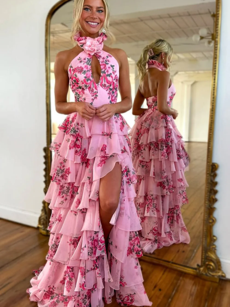 Front view of a pink floral print halter neck A-line prom dress with a thigh-high slit.