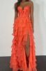 Front view of a coral strapless prom dress with cascading layered ruffles.