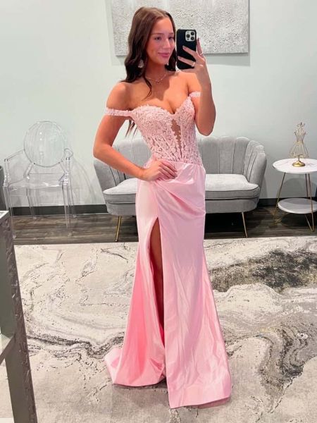 Front view of a romantic blush pink off-the-shoulder prom dress adorned with lace applique.