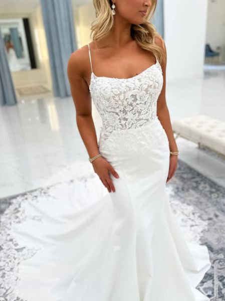 Front view of a lace applique mermaid wedding dress with a sweeping chapel train.