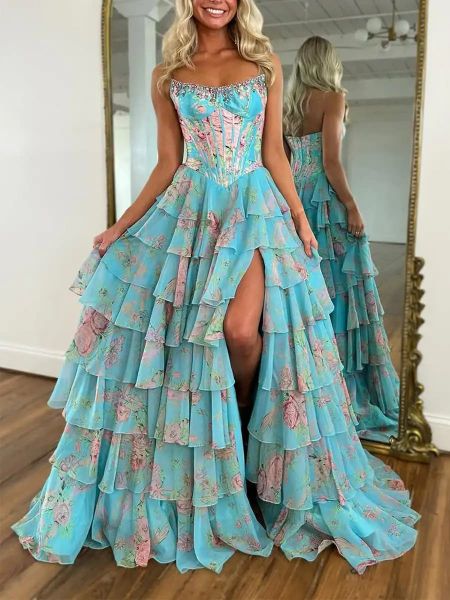 Front view of a blue strapless prom dress with an all-over floral print, layered skirt, and high slit.