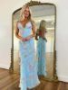 Front view of a light blue prom dress with delicate spaghetti straps, floral ruffles, and a backless design.