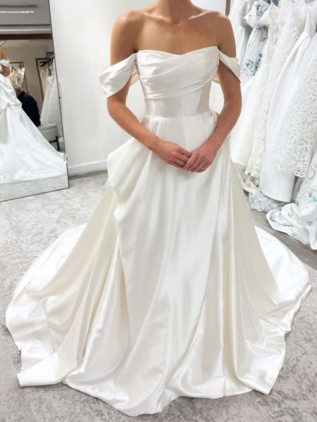 Front view of an elegant ivory A-line wedding dress with a romantic off-the-shoulder neckline.