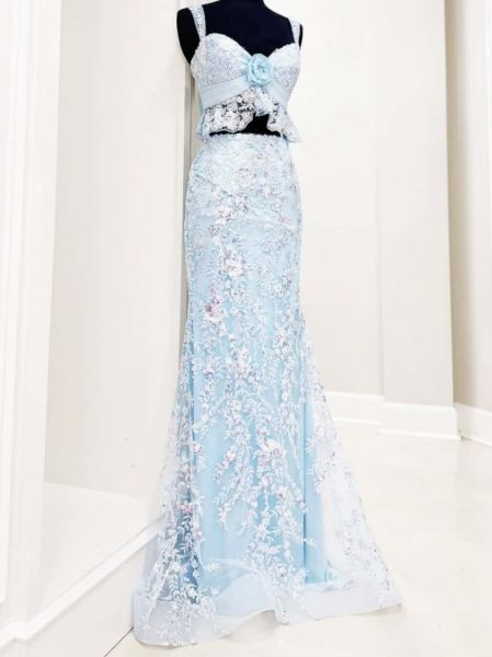 Front view of a modern light blue two-piece prom or cocktail dress with a sequined top and mermaid skirt.