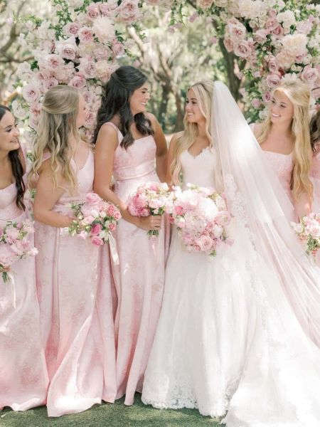 Front view of a pink floral print sheath bridesmaid dress with a sleeveless design.
