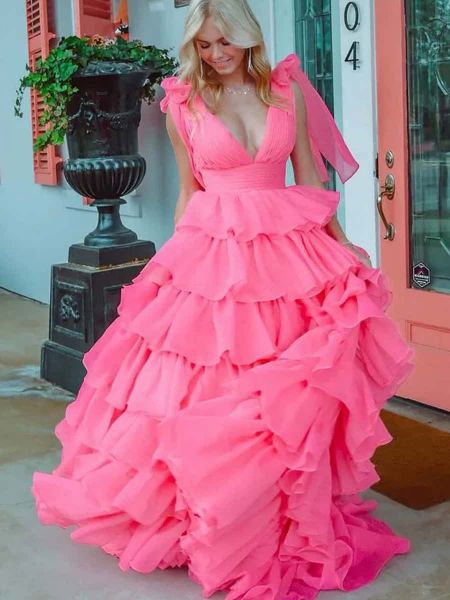 Front view of a pink prom dress with a V-neckline and a cascading ruffle skirt.