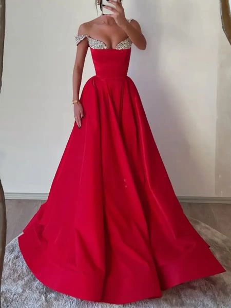 Front view of a red off-the-shoulder prom dress with shimmering crystal embellishments.