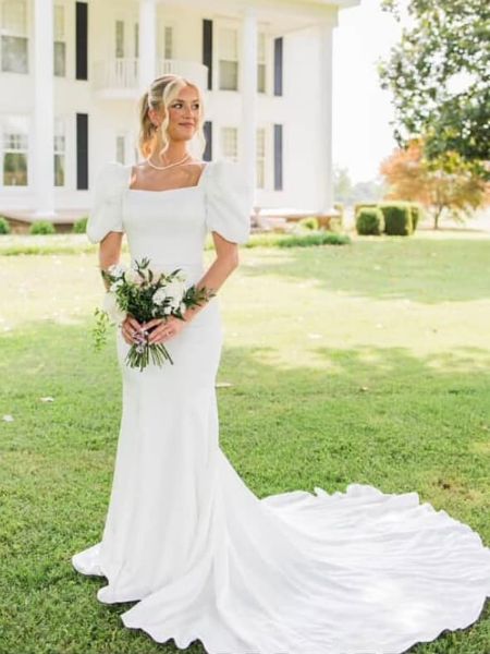 Front view of an elegant puff sleeve mermaid wedding dress with a train.
