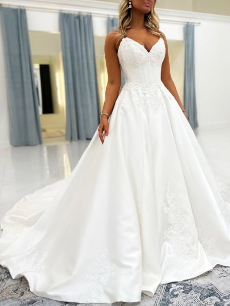 Front view of a lace A-line wedding dress with thin spaghetti straps.