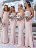 A bridal party of four wearing the light pink mermaid bridesmaid dresses, standing together in a garden ceremony setting with floral arrangements.