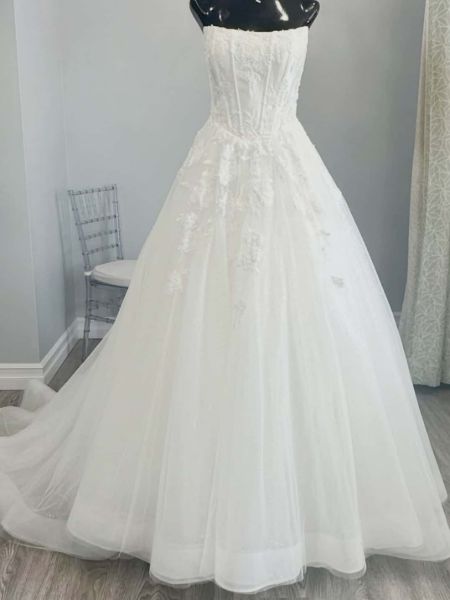 Strapless wedding dress with a lace applique bustier bodice and a flowing A-line or ballgown skirt.