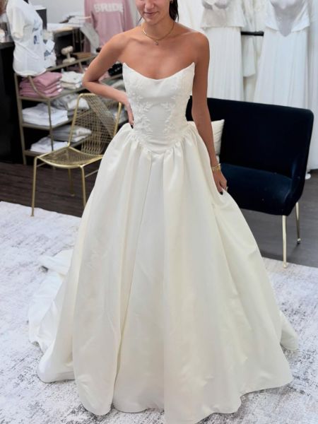 Ivory strapless wedding dress in satin, featuring delicate lace embroidery on the bodice and skirt.