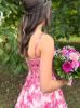 Back view of the pink floral print dress, showing the fitted back and graceful cut.
