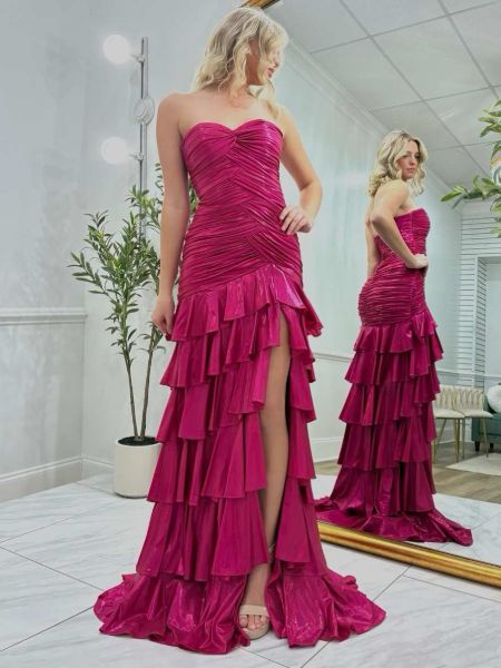 Strapless hot pink prom dress with cascading ruffles and a dramatic high slit.