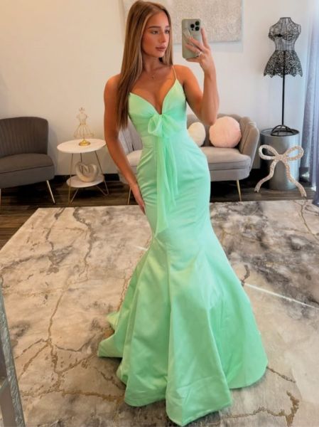 Mint green mermaid formal dress with deep V-neckline and statement bow accent.