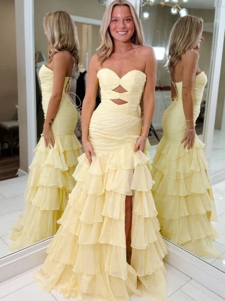 Yellow strapless mermaid prom dress with cutouts, cascading ruffles, and dramatic flare.