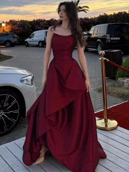 Burgundy satin asymmetrical evening dress with single shoulder strap and elegant floor-length silhouette.