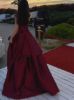 Back view of burgundy satin asymmetrical dress, showing elegant back and sleek silhouette.