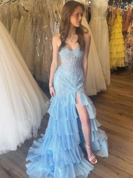 Layered mermaid light blue prom dress with applique details, fitted silhouette, and cascading tiered skirt.