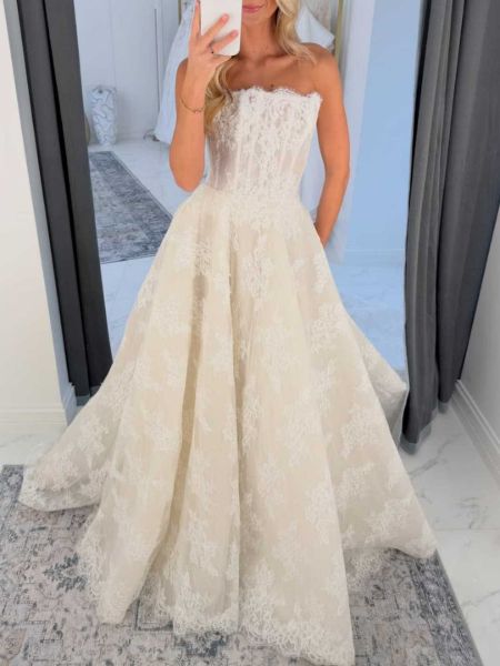 Vintage ivory lace strapless wedding dress with corset bodice, and flowing skirt.