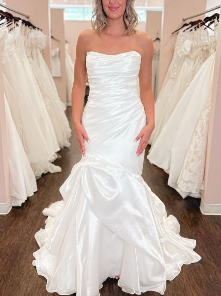 Elegant white mermaid ruched satin wedding dress with fitted silhouette, ruching detail, and dramatic train.