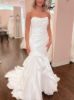 Side profile of mermaid wedding dress highlighting fitted hips, dramatic knee-level flare, and flowing train.