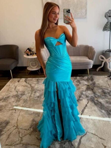 Turquoise sweetheart mermaid prom dress with dramatic bow accent and curve-hugging silhouette.