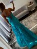 Back view of turquoise mermaid dress showing dramatic bow placement, fitted silhouette, and elegant train.