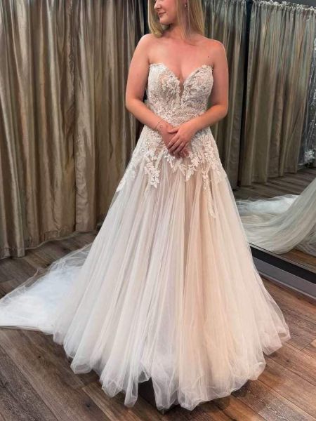 Romantic ivory tulle bridal gown with delicate lace appliqués, fitted bodice, and ethereal full skirt.